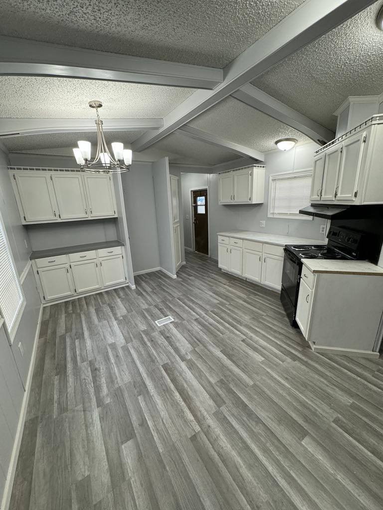 Dining area with a chandelier, built-in hutch and the kitchen beyond