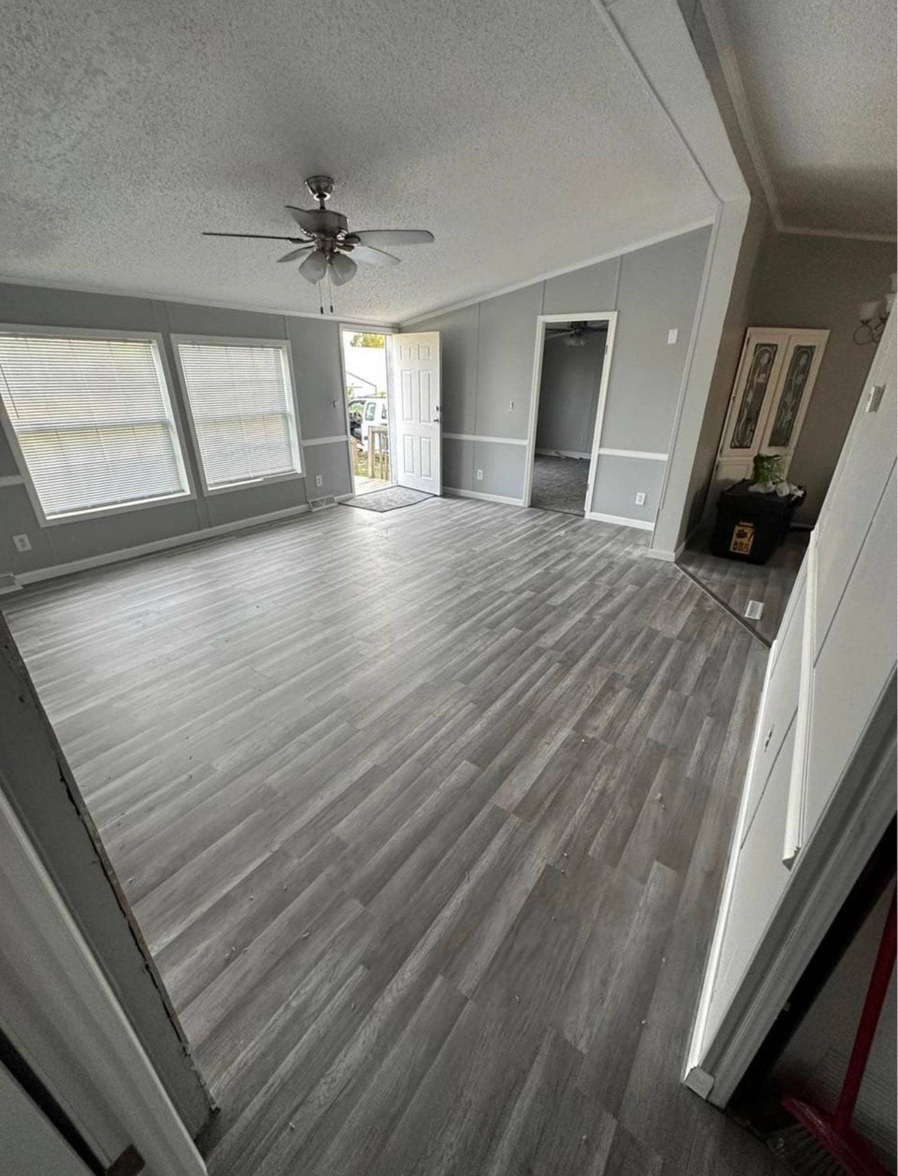 Bright living room with a wide bank of windows and gray plank flooring